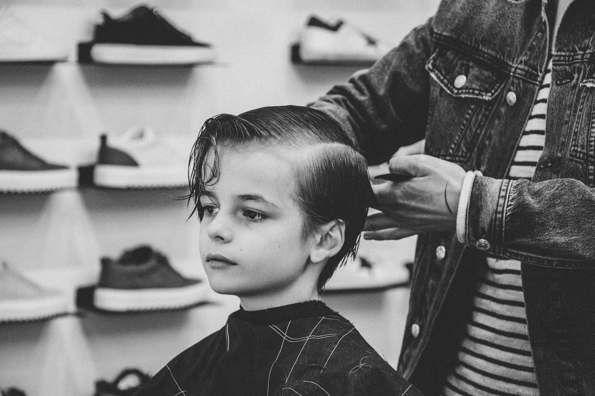 greyscale photo of boy having a haircut